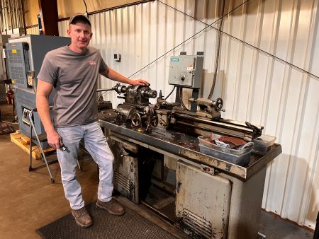 Scott Trulock with the original lathe used by his late father when starting their choke-making business.